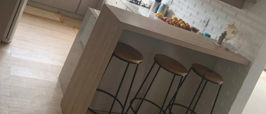 Cozinha planejada com ilha, bancada de refeições e banquetas
