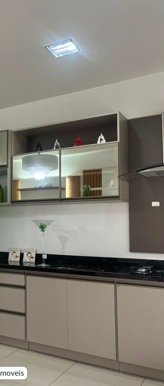 Cozinha planejada com armários fendi, bancada de granito preto e aéreos espelhados